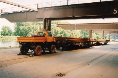 2-Wege-Unimog U406 mit 2 beladenen Werkswagen,<br />im Hintergrund der Nordhafen sowie Krananlagen,<br />hier werden Schiffe be- oder entladen